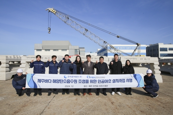 바다숲 조성을 위해 선적 대기중인 인공어초 앞 관계자들의 기념촬영 모습. [사진=중부발전]