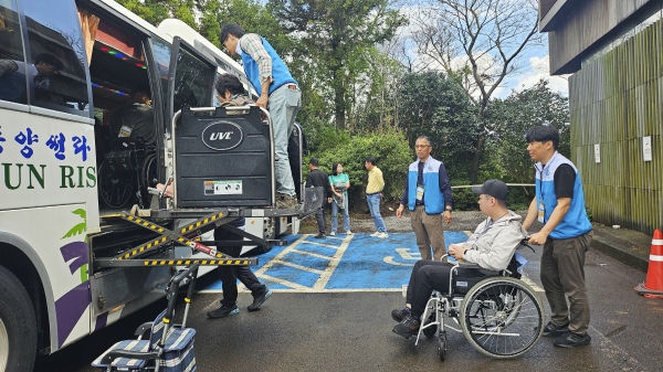 자원봉사자들의 이동보조 모습 [사진=중부발전]